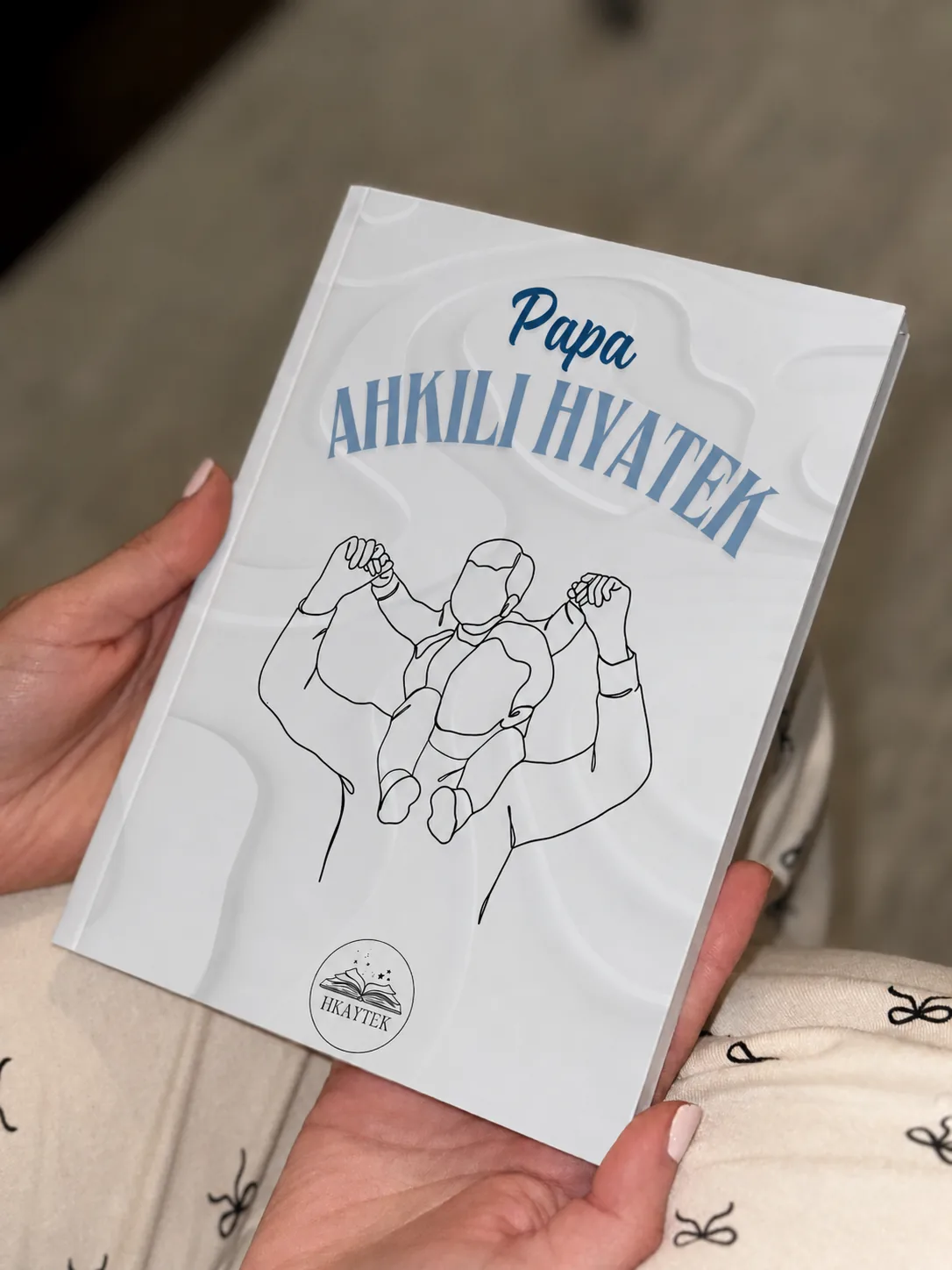 Le livre Papa, Ahkili Hkaytek, tenu en main
